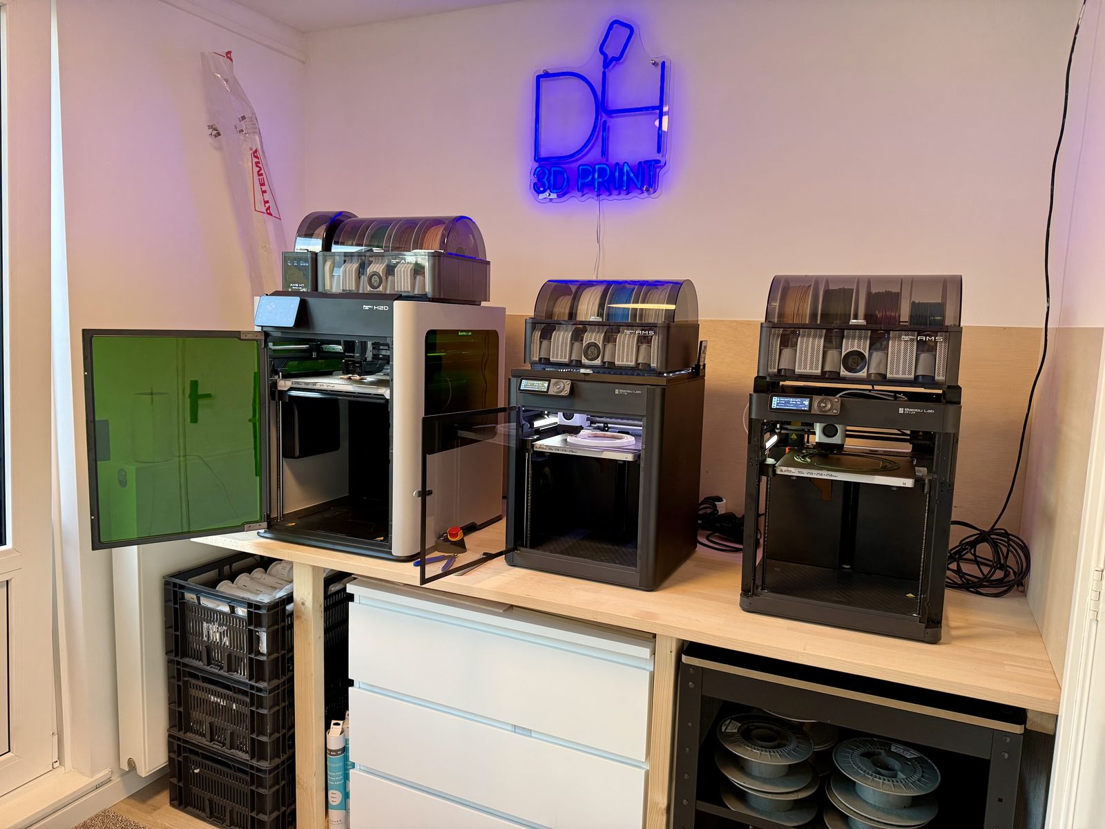 Printfarm van DH 3D Print met meerdere printers en een neonlogo